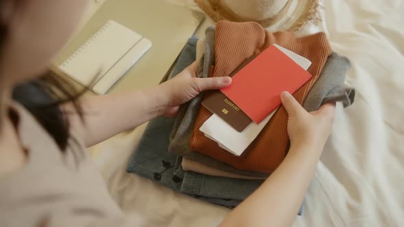 asian female traveller hand arrange cloth stuffs passport smartphone with digital vaccine passport