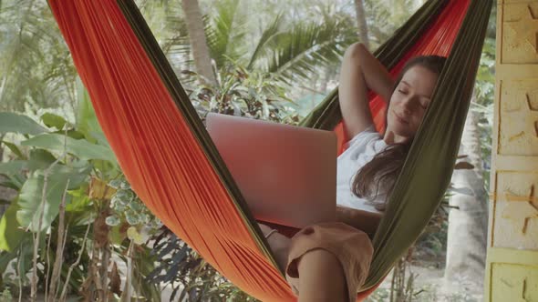 Natural Model Sitting Hammock Typing Laptop Keyboard Outdoors Nature Background alt