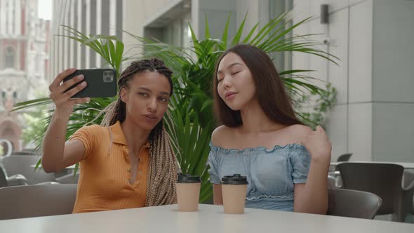 Two Happy Girlfriends Have a Video Chat with Friends Wave your Hand at the Camera on Their alt