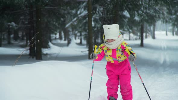 Little Girl Trying To Skiing in the Forest alt