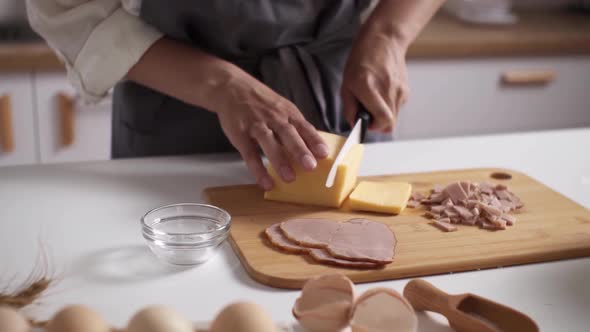 Slicing Hard Cheese. Women's Hands Cut Cheese, Meat Table. Dinner Preparation. Man Prepares Dinner alt