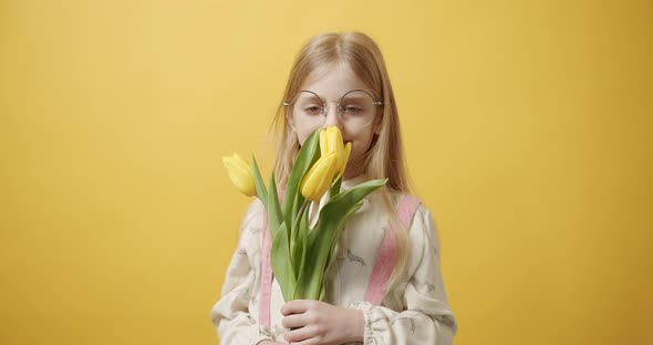 Beautiful Girl Holds Tulip Flowers in Her Hand She Smiles on Yellow Background alt