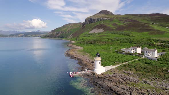 A Ferry Moored at a Jetty and Lighthouse Delivering Cargo and Goods alt