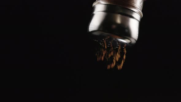 Red Pepper Falling Out From Pepperpot on Black Background in Slomo alt