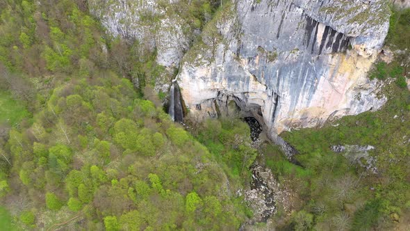 Flying Above a Waterfall and a Big Cave Entrance alt