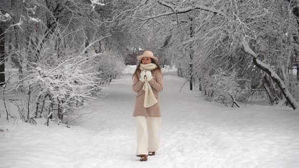 Portrait of young happy woman walking outdoors in winter park alt