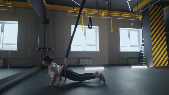 Suspension Training in Gym Young Sporty Woman is Training Alone in Fitness Club Keeping Fit alt