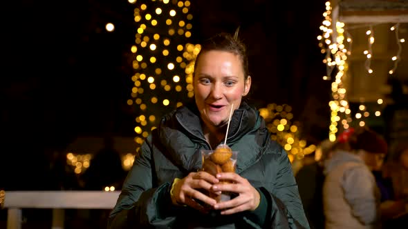 Woman holding traditional food at Christmas market. Zagreb, Croatia alt