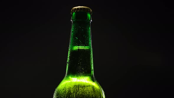 Green Beer Bottle Spins in Dark