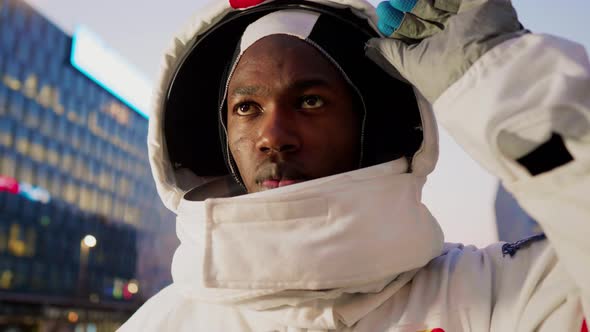 Spaceman opening helmet visor in city alt