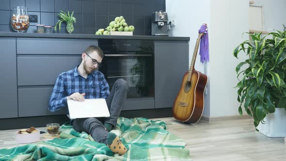 Tired man typing on keyboard and closing notebook after work alt