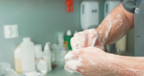 Close Up Hands of Male Veterinarian in Foam While He Washes Hands Before an Operation At the alt