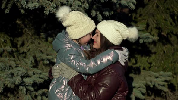 Happy Girl 78 Years Old Kissing Mother on a Walk in the Winter Forest