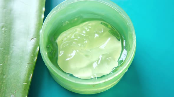 Fresh Aloe Vera Sliced and Liquid Gel in Plastic Container on White Background alt