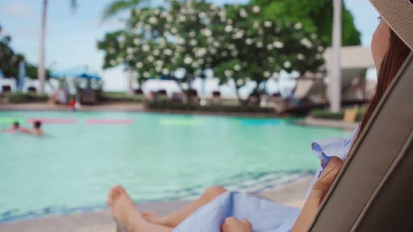 Young woman traveler enjoying a summer vacation at swimming pool