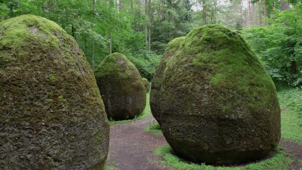 slow drone overflight rocks in the form of huge eggs overgrown with moss Europe park near Vilnius Li alt