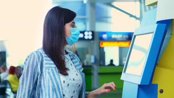 Close-up, a Young Woman Checks in on Self Check-in Kiosk at the Airport. Air Travel Opening After alt