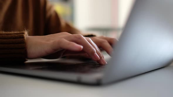 Closeup a woman working and typing on laptop computer keyboard on the table