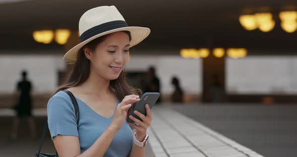 Woman use of mobile phone in city alt