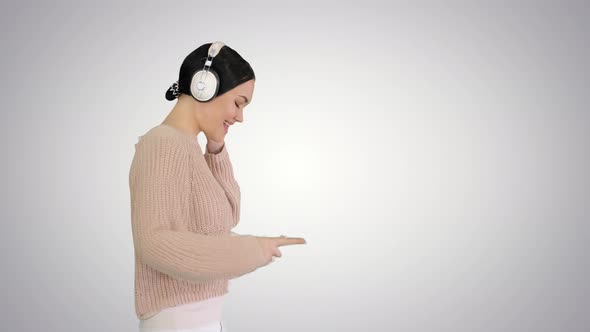 Smiling Female with Headphones Walking and Enjoying the Music on Gradient Background alt