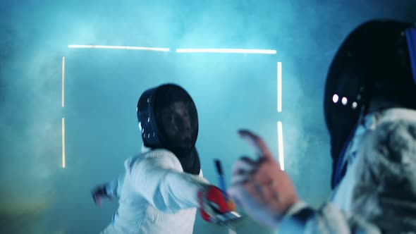 Two Fencers are Having a Training Session in Clouds of Smoke alt