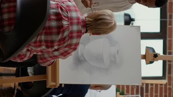 Vertical Video Male Teacher Giving Advice to Elder Woman in Drawing Class alt