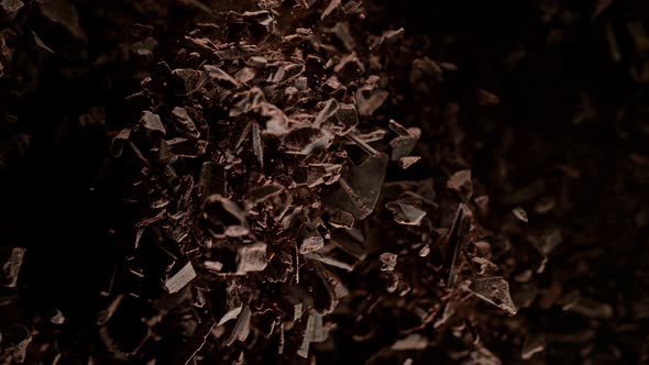 Super Slow Motion Shot of Raw Chocolate Chunks and Cocoa Powder Exploded Towards Camera at 1000Fps alt