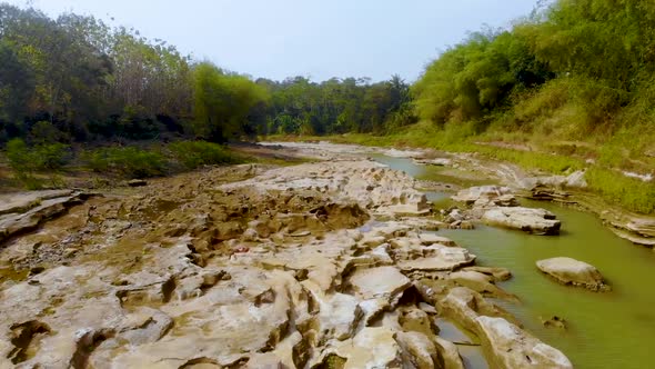 Bogowonto River eroded riverbed in jungle aerial view, Java, Indonesia alt
