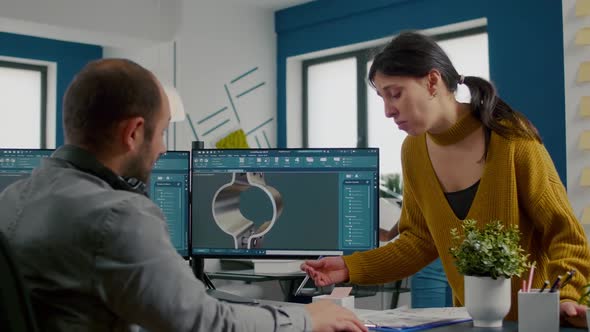 Team Discussing About Industrial Project Using Dual Monitors Setup alt