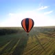 Black and orange hot air balloon floating above green field - VideoHive Item for Sale