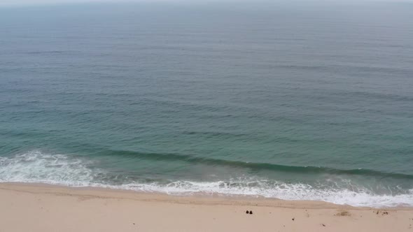 AERIAL: drone, half moon bay beach cliffs and shore, ascending view alt