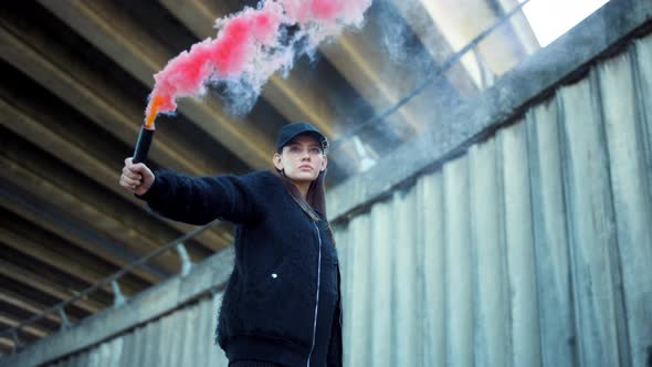 Woman with Smoke Bomb in Hand Looking at Camera, Girl Standing on Urban Street alt
