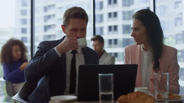 Two Professionals Discussing Business Project at Laptop Online Meeting in Cafe alt