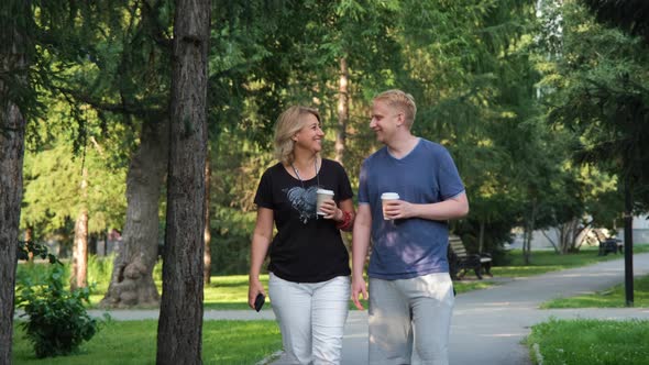 Male with Mature Mother Walking in a City Park alt