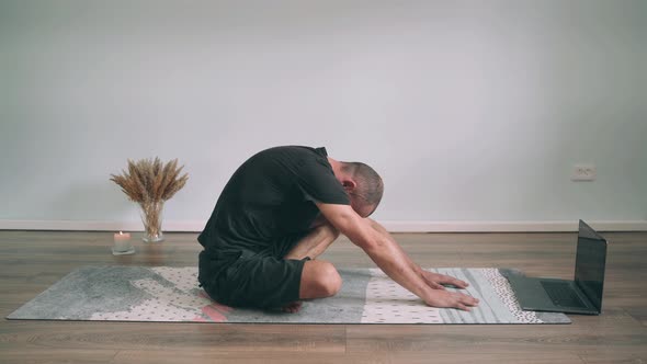 Caucasian Man Does Yoga Online Man Sits in the Lotus Position and Stretches His Arms Forward Yoga
