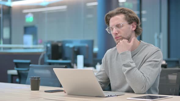 Young Businessman with Laptop Taking Nap in Office alt