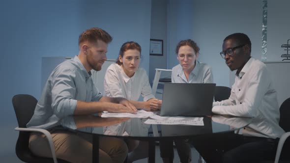 Group of Young Modern People in Smart Casual Wear Discussing Business Sitting in Creative Office alt