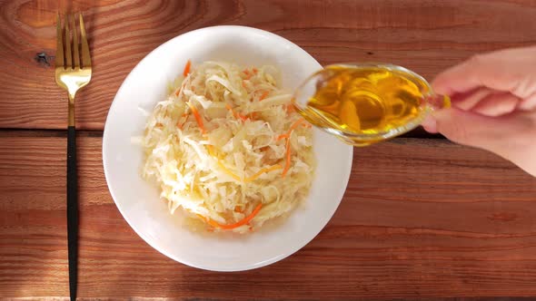 Eating Sauerkraut with vegetable oil. National european dish Pickled cabbage carrot alt