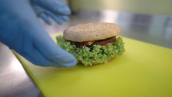 The Cook Puts a Freshly Cooked Burger in a Paper Bag