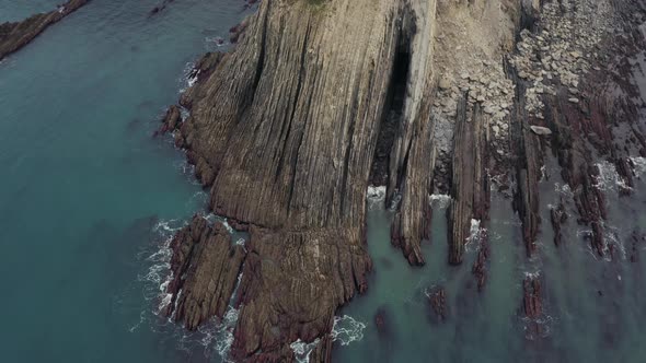 Aerial; top down view of sea coast with beautiful stones and turquoise water, Plentzia, Spain