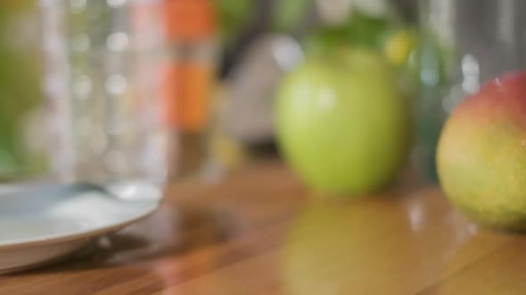 Slices Of Green Apples Falling Into Chopping Board With Water Splashes. - close up, slow motion alt