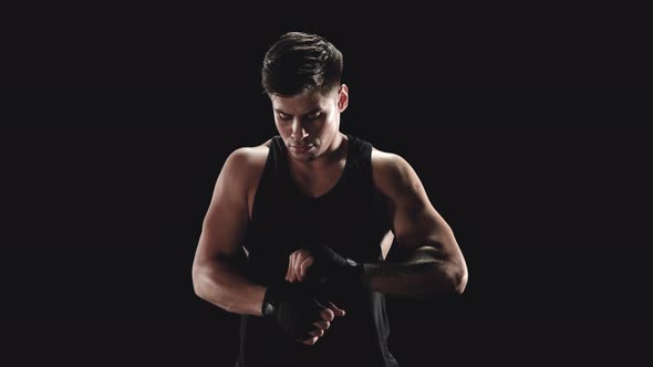 Young Man Wrapping Hands with Boxing Wraps alt