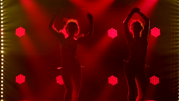 Portrait of Tender Girl in Red Dress Is Dancing and Enjoying Music in Big Red Headphones. Green alt