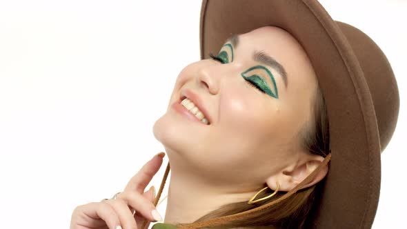 Woman in a Autumn Look in Studio in Green Parka and Hat Turns and Poses To the Camera