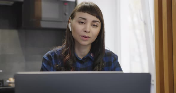 Portrait of Woman with Wireless Headset Talking on a Video Link on the Internet alt