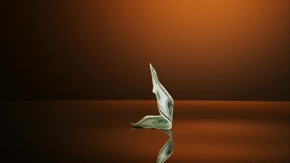 American $100 Bills Falling onto a Reflective Surface alt