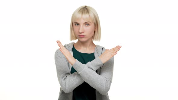 Portrait of Woman with Bob Haircut in Sweatshirt Strictly Gesturing with Hands in Crossed Meaning alt
