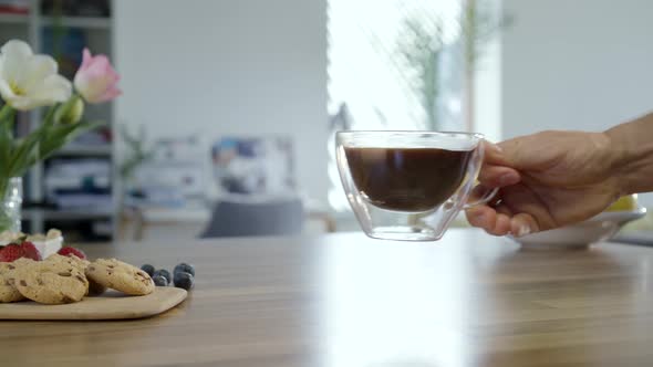 Hand Taking Cup Of Coffee And Placing It Back