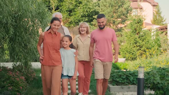 Happy Multigenerational Family Walking In Yard alt