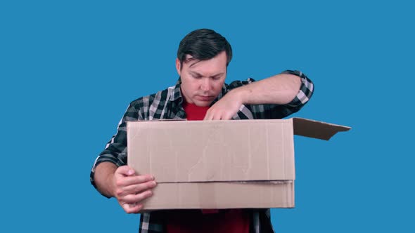 Excited Young Man Unpacking Cardboard Box with Online Order Happy Caucasian Man Opening Cardboard
